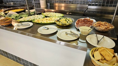 a buffet line with plates and bowls of food on it - 