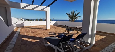 una terraza con sillas y una mesa con vistas al océano