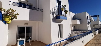 a white building with a blue railing and balconies