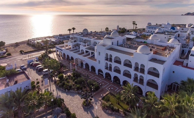 an aerial view of a large white building near the ocean