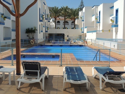 una piscina rodeada de edificios blancos y azules - 