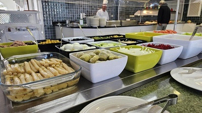 a buffet line with asparagus artichokes and other vegetables - 