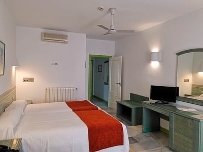 a hotel room with two beds and a ceiling fan