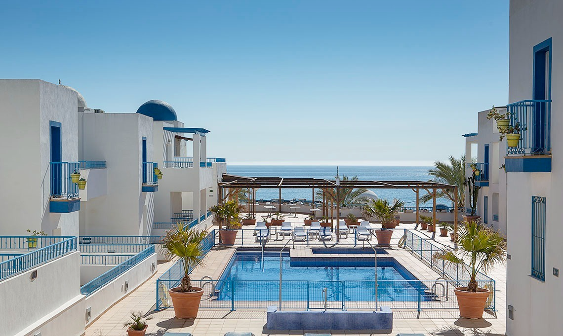 a large swimming pool is surrounded by white buildings