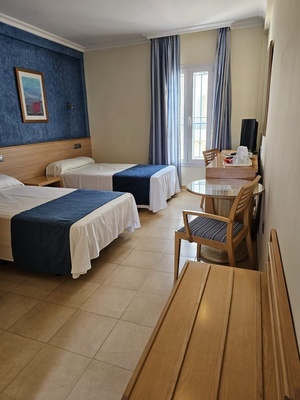 a hotel room with two beds and a table