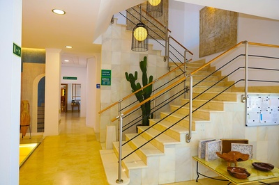 Escaleras modernas en El Puntazo: diseño luminoso con cactus y arte. - 