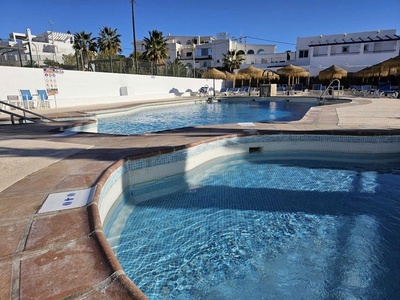 una piscina al aire libre con una señal de advertencia en la pared - 