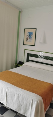 a hotel room with a bed and a picture on the wall