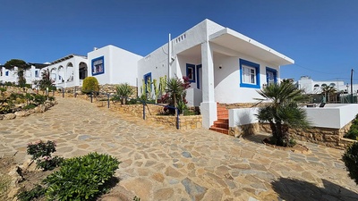 una casa blanca y azul con escaleras que conducen a ella - 