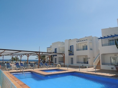 una piscina azul está rodeada de edificios blancos y azules - 