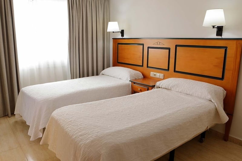 a hotel room with two beds and a wooden headboard