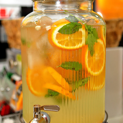 Jarra de limonada PYR Fuengirola con naranjas y menta, ideal para tu evento.