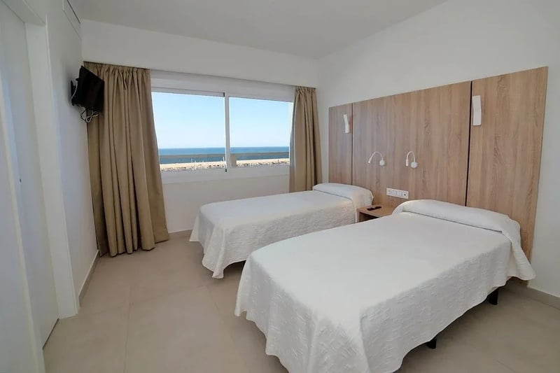 une chambre avec deux lits et une télévision à l' arrière