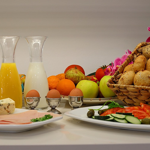Desayuno continental en hotel: PYR Fuengirola, jugos, frutas, panes, huevos y charcutería.