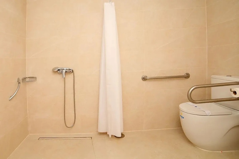 a bathroom with a toilet and a shower with a white curtain