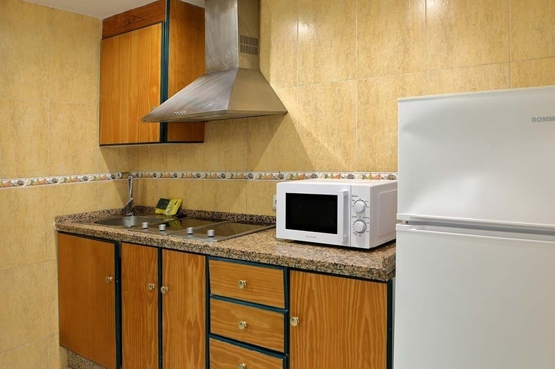 a kitchen with a microwave and a rommer refrigerator