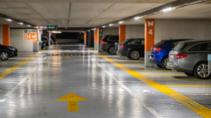 Parking souterrain PYR Fuengirola, bien éclairé avec signalisation directionnelle et voitures garées.