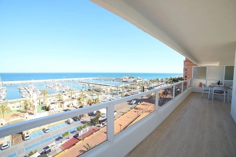 una vista del océano desde un balcón con una mesa y sillas