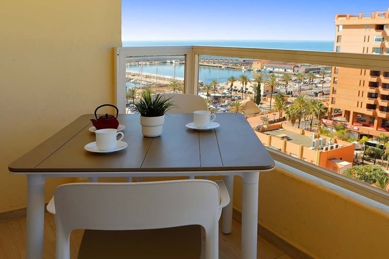 a balcony with a table and chairs and a view of the ocean