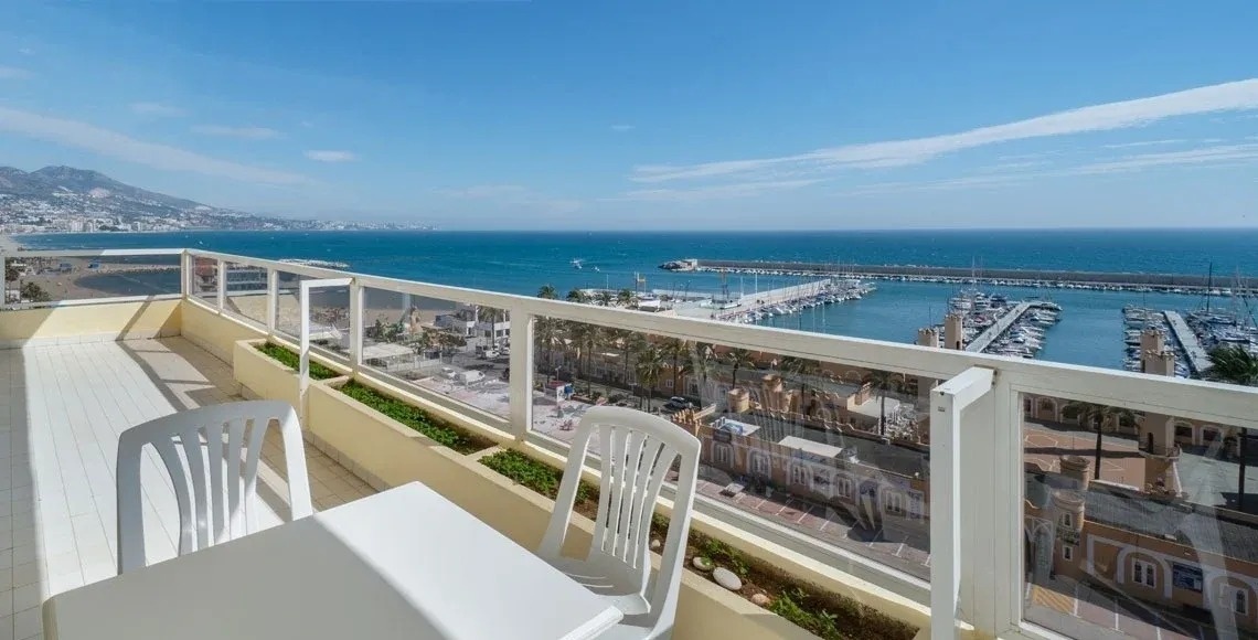 a view of the ocean from a balcony with a table and chairs