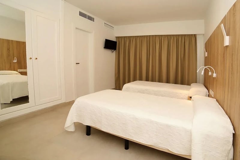 une chambre avec deux lits et une télévision à l' arrière