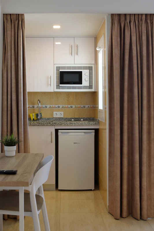 a kitchen with a small fridge and a microwave