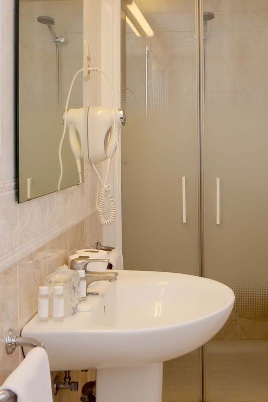 a bathroom with a sink a mirror and a hair dryer