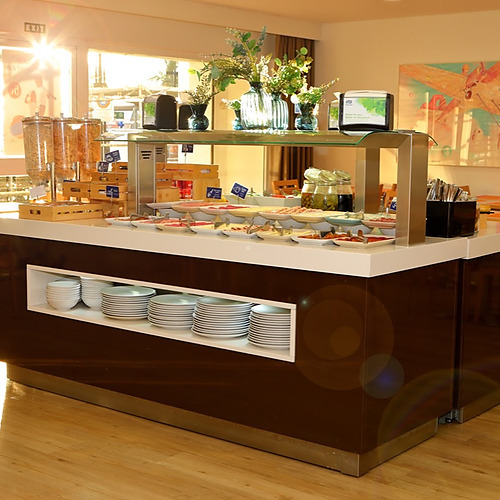 Desayuno buffet en hotel con PYR Fuengirola y mesas de madera, luz natural brillante.