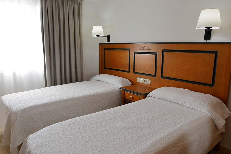 two beds in a hotel room with a wooden headboard