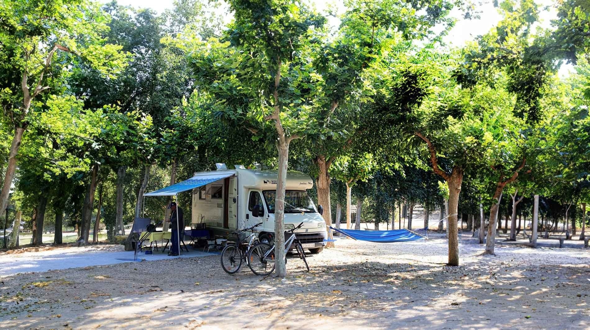 un camping-car avec un hamac et des vélos garés devant