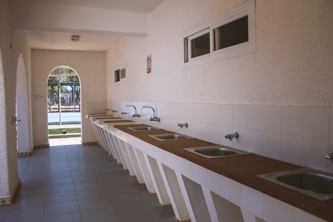 een badkamer met witte muren en witte wastafels