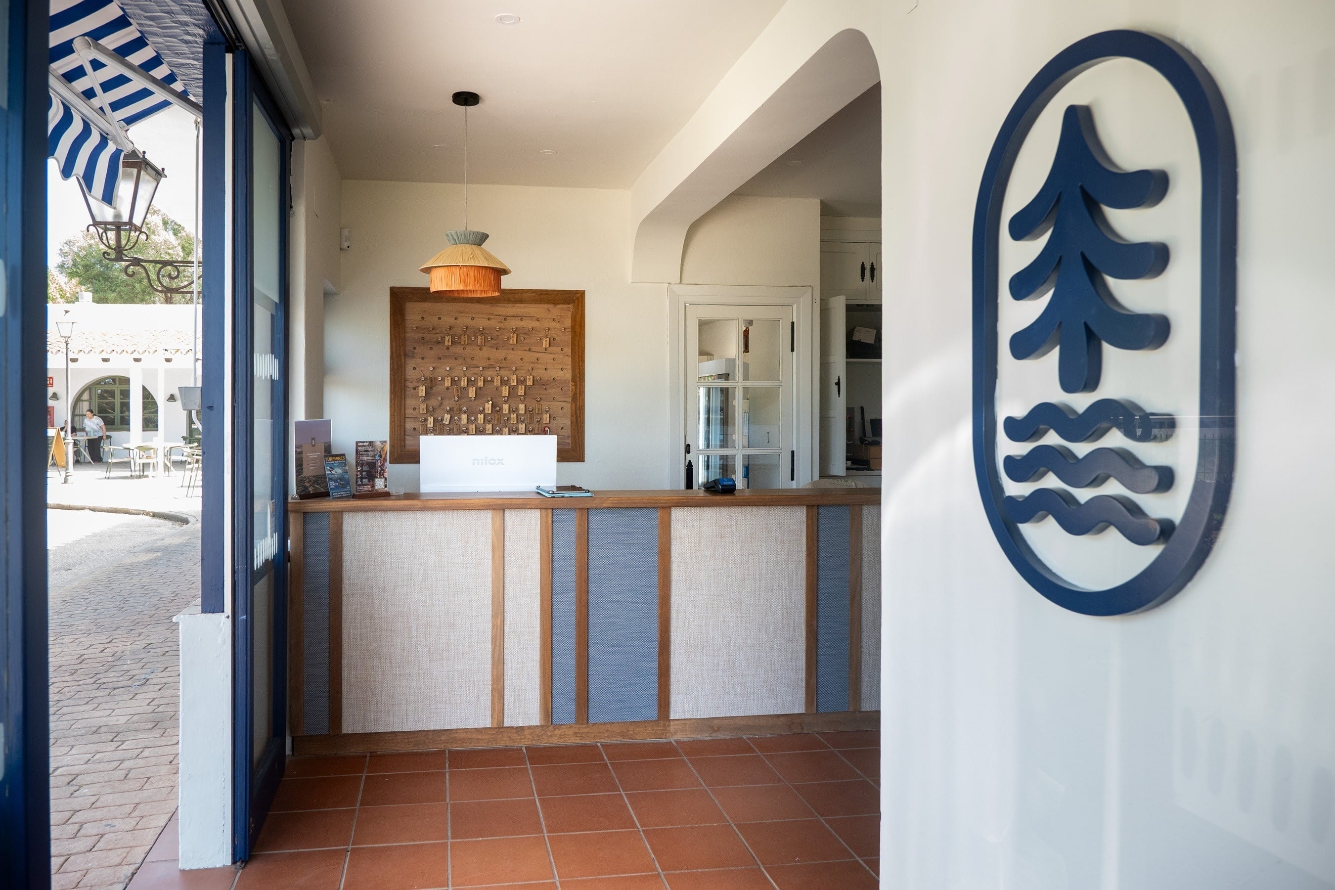 Recepció de TAIGA Tarifa Valdevaquers, amb taulell modern, rètols de fusta i logo distintiu TAIGA.