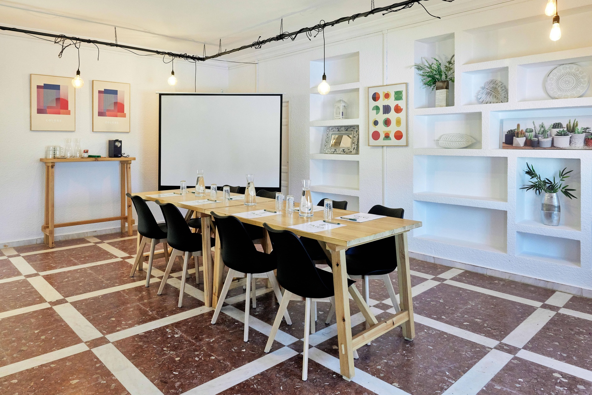 a room with tables and chairs and a projector screen