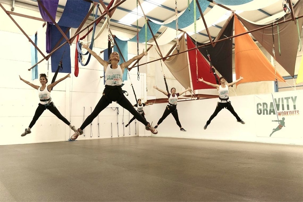 un grup de dones salta en el aire en un saló de gravity workouts