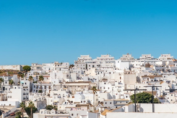 a row of white buildings with a blue sky in the background