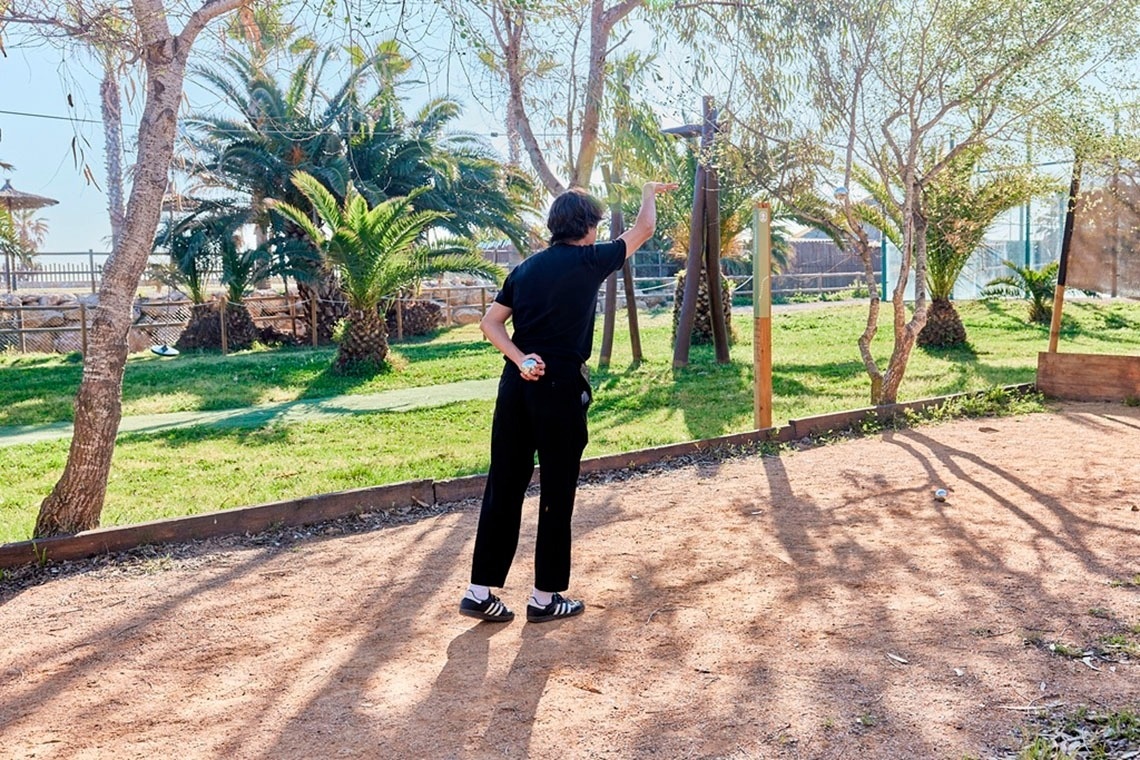 a person wearing black adidas shoes is standing in a park