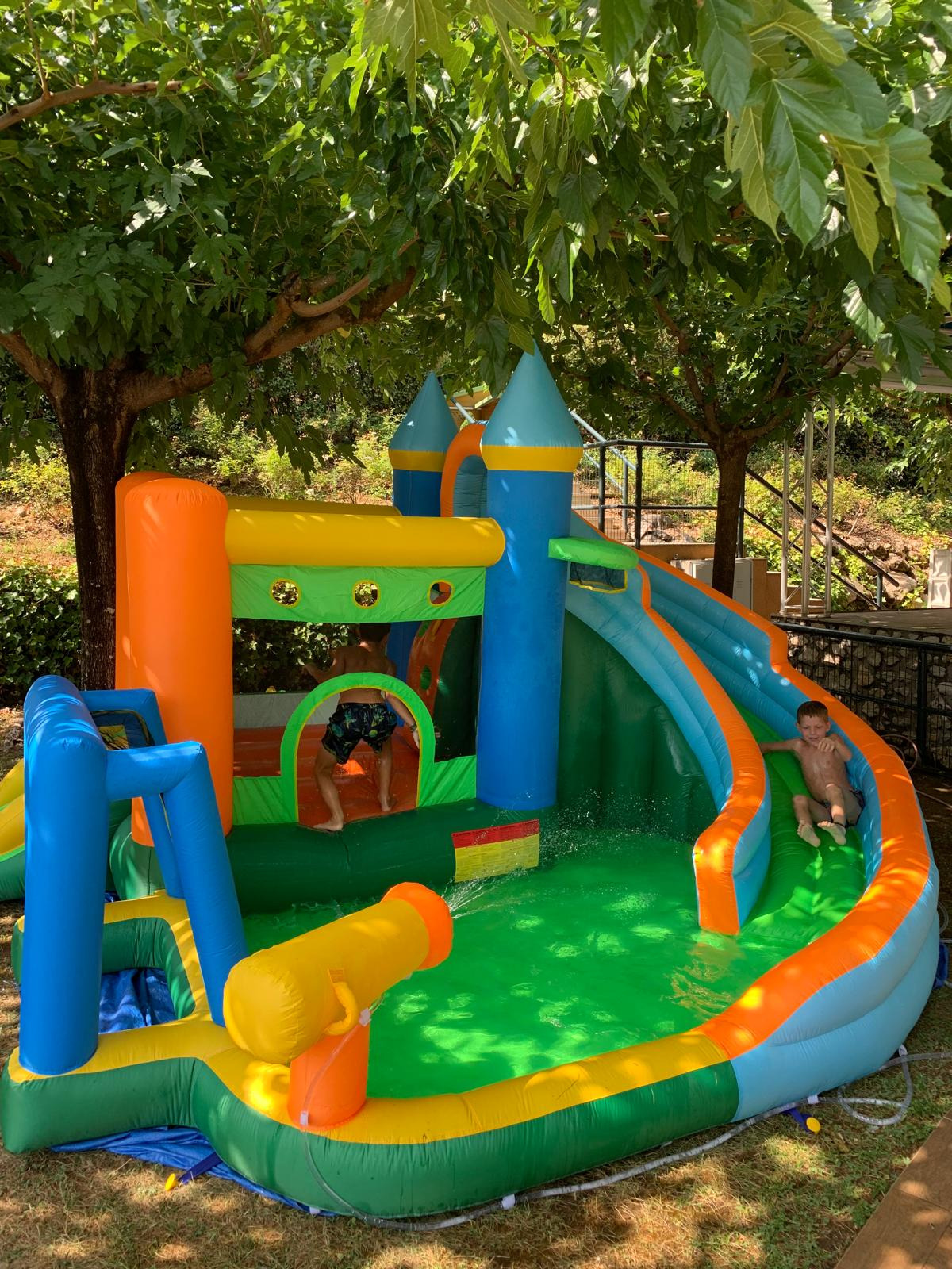 Nen del parc aquàtic inflable amb tobogan i canó d'aigua. Taiga: Corporativa ideal per a hotels familiars.