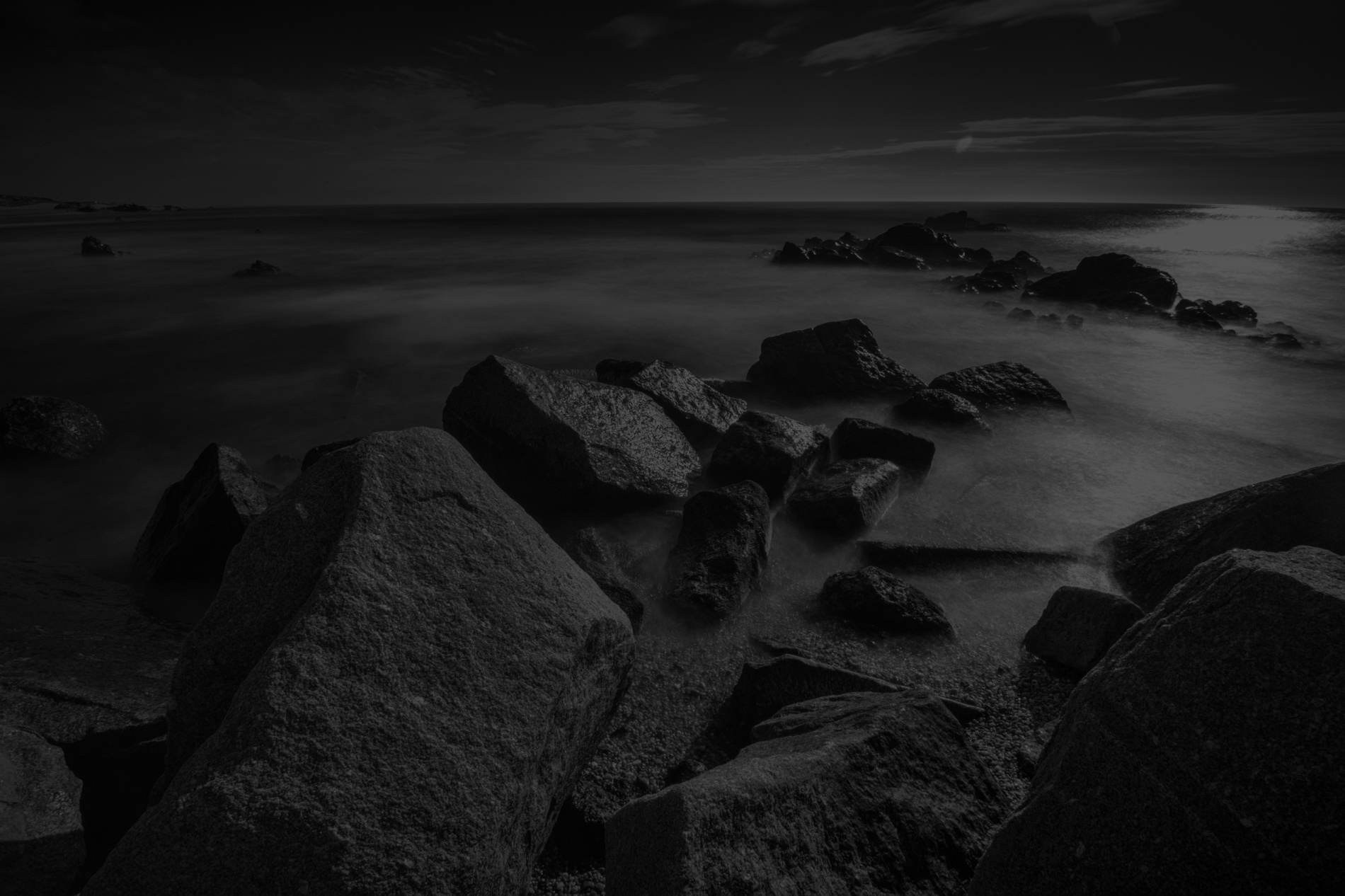 Taiga: Corporativa - Strandsonnenuntergang mit Felsen und lila Himmel.