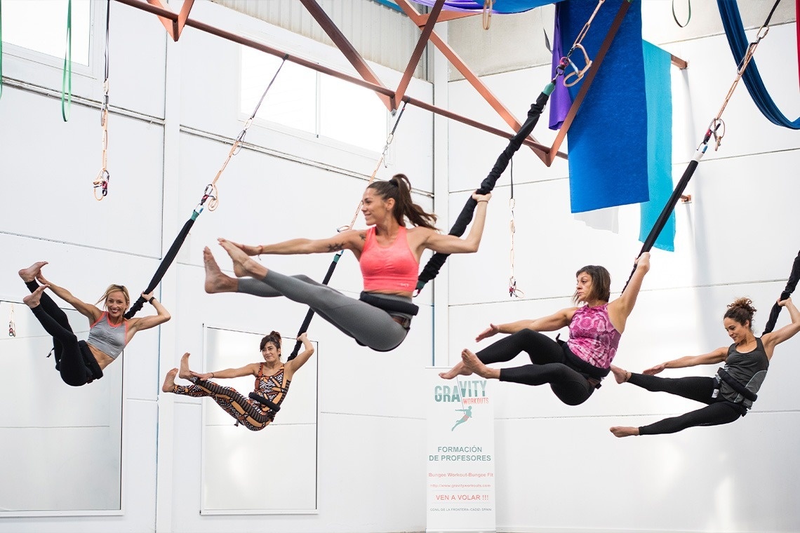 a group of women are doing yoga in front of a sign that says gravity fitness