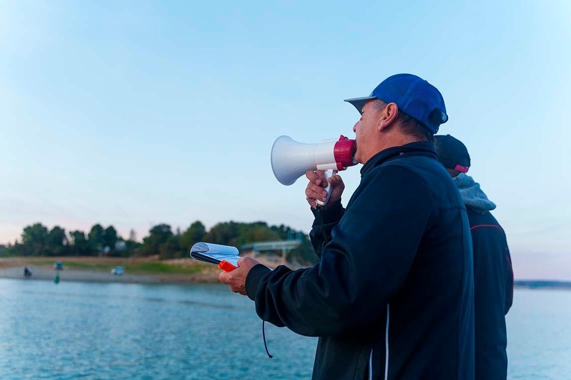 un barco azul y blanco está amarrado frente a una casa flotante