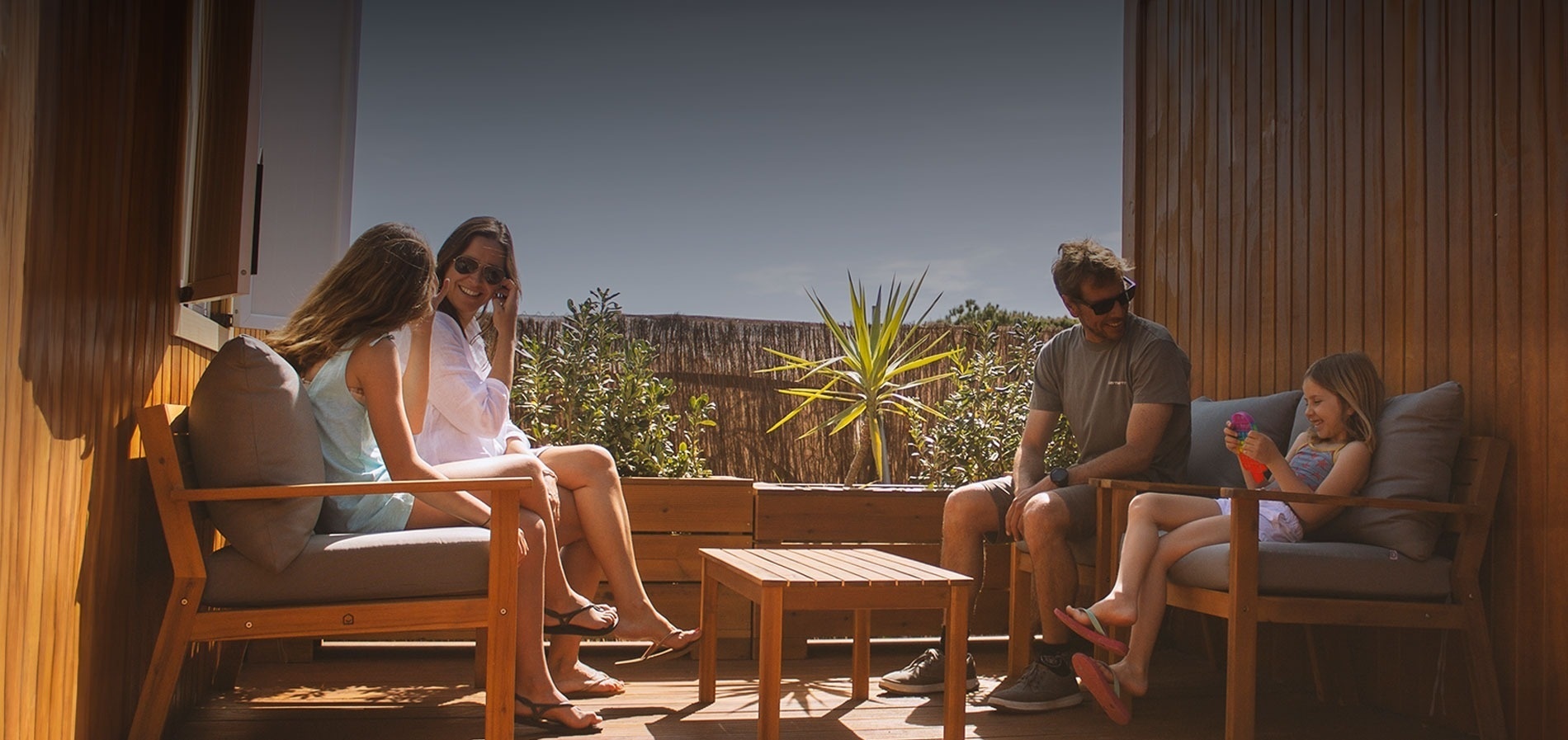 une famille est assise sur une terrasse en bois