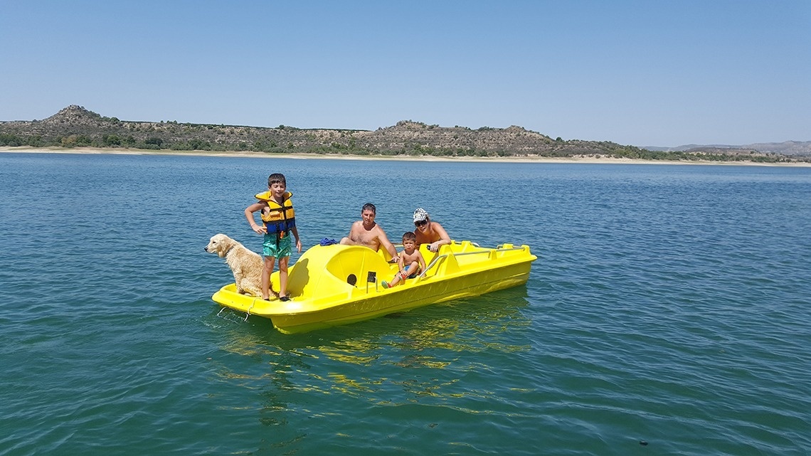 un groupe de personnes sur un bateau pédalo jaune sur un lac