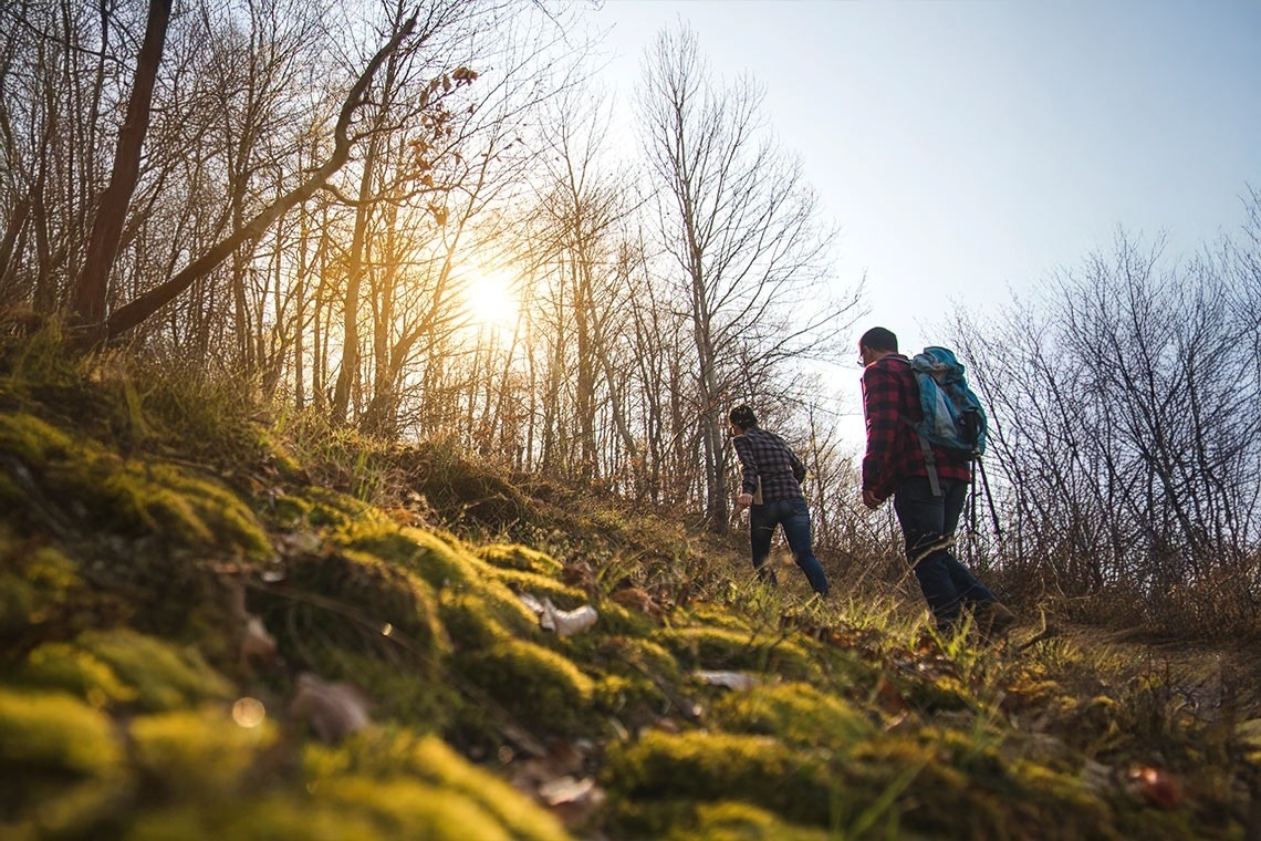 two people walking down a path in the mountains