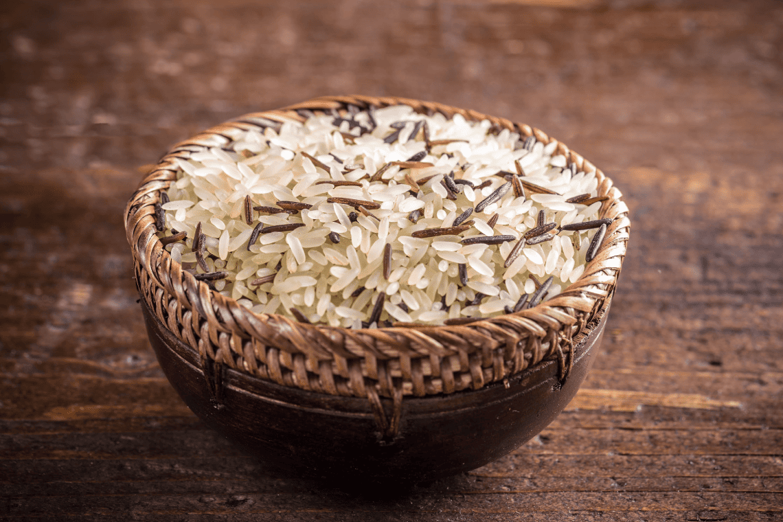 a wicker bowl filled with white and brown rice