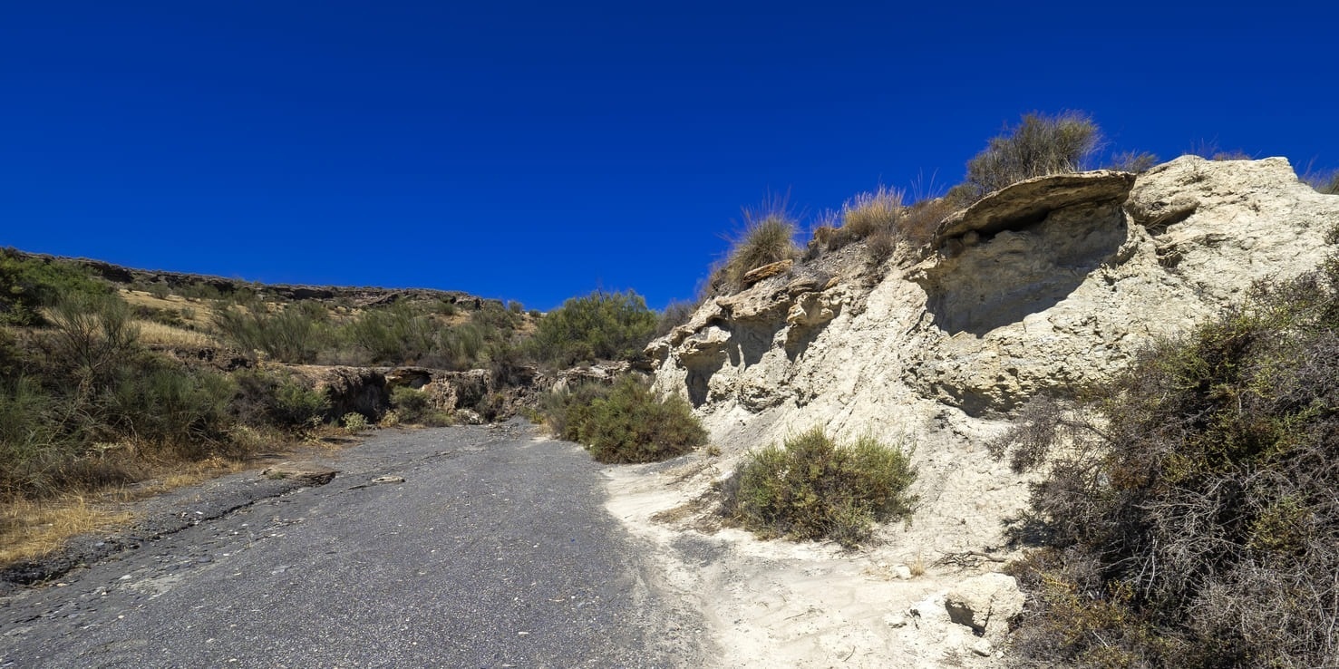 a rocky hillside with a blue sky in the background
