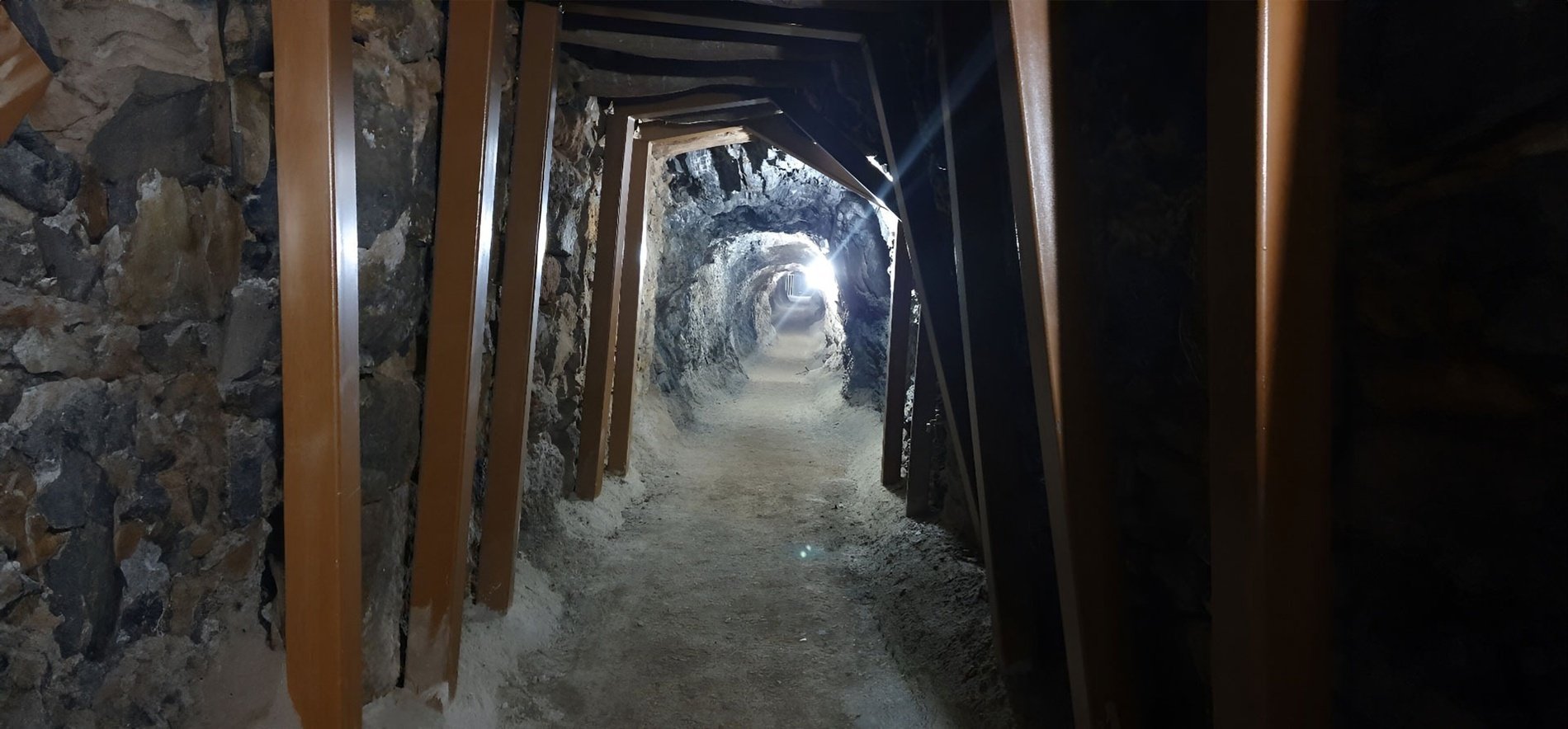 una luz brilla a través de un túnel de madera