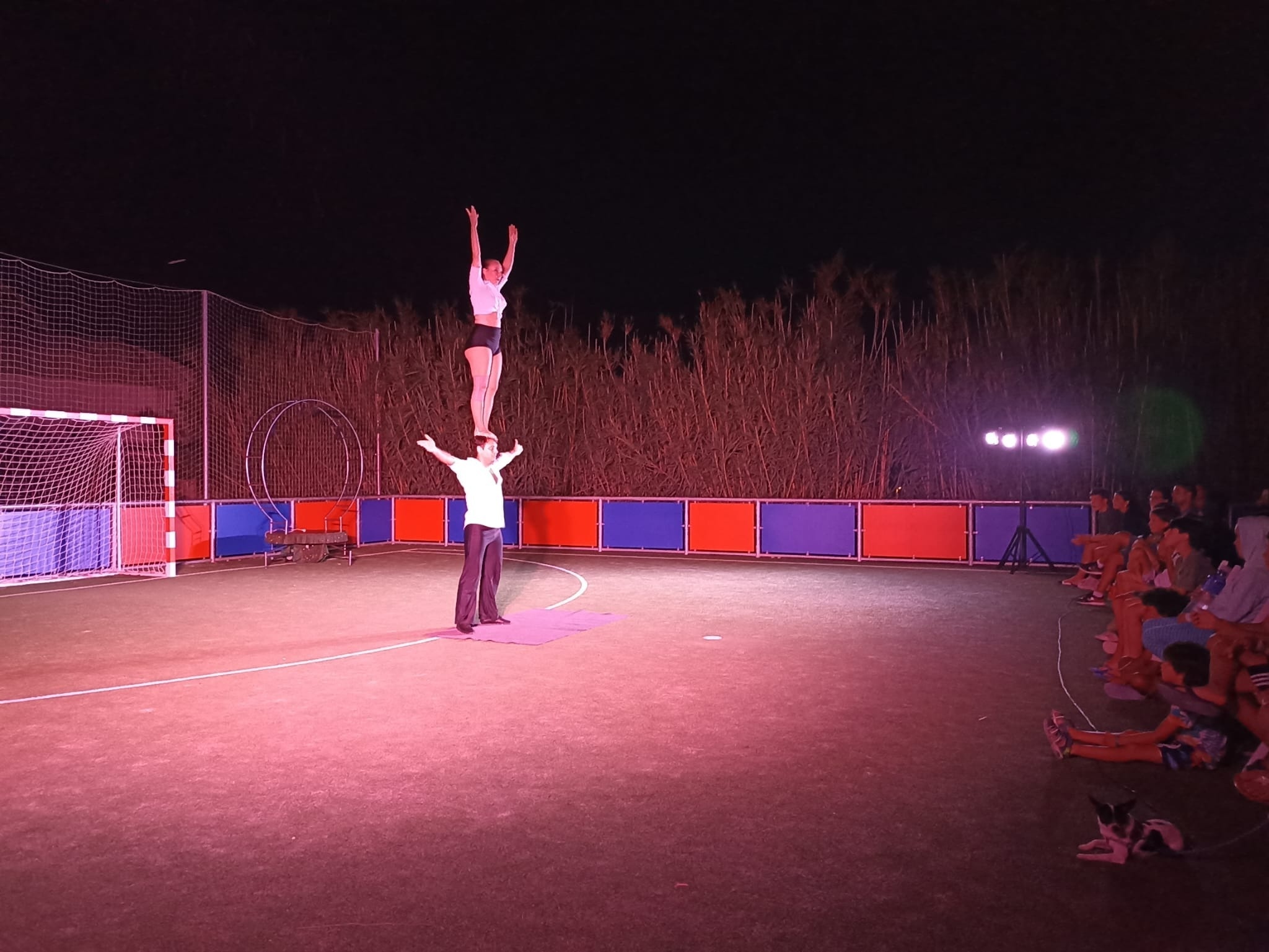 a man and a woman perform acrobatic stunts on a basketball court