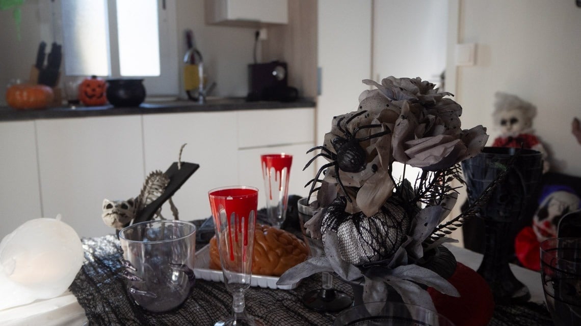 una mesa decorada para halloween con copas rojas y blancas