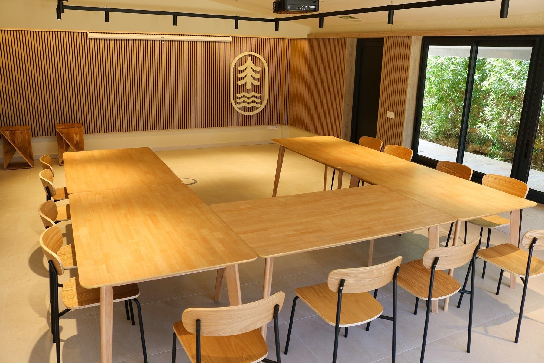 una sala de reunions amb unes taules de fusta i unes cadires