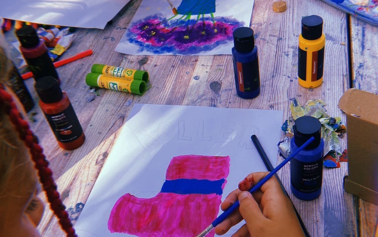 two little girls are running in the grass holding hands